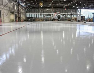 Airplane Hanger with Epoxy Coating showcasing a glossy, durable floor finish designed for heavy-duty aircraft environments and long-lasting performance.
