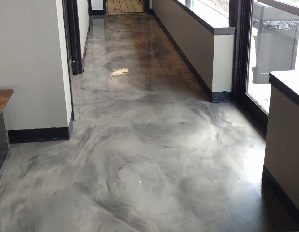 Marble Polished Concrete Flooring in a commercial hallway featuring a smooth, high-gloss finish with gray and black marbling for a sleek, modern appearance.